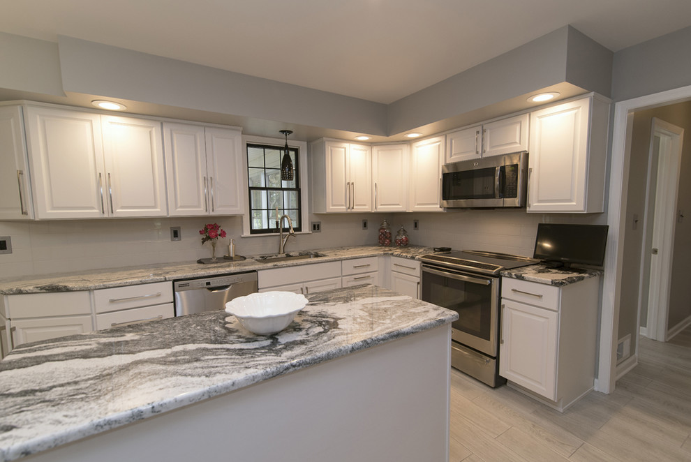 Inspiration for a mid-sized contemporary u-shaped ceramic tile and gray floor eat-in kitchen remodel in Baltimore with an undermount sink, raised-panel cabinets, white cabinets, granite countertops, white backsplash, ceramic backsplash, stainless steel appliances and an island