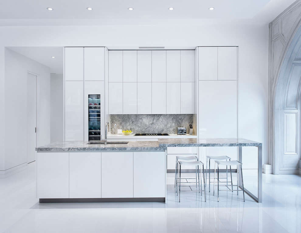 Inspiration for a scandinavian galley kitchen in New York with a submerged sink, flat-panel cabinets, white cabinets, grey splashback, integrated appliances and an island.