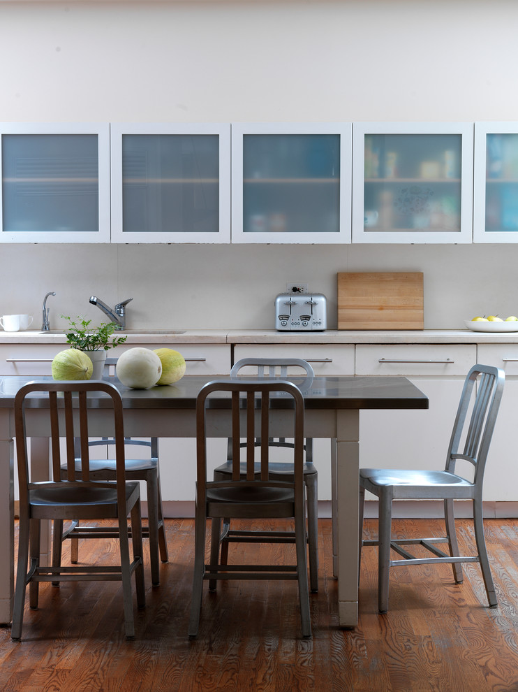 Foto de cocina comedor actual con fregadero bajoencimera, armarios tipo vitrina, puertas de armario blancas y suelo de madera oscura