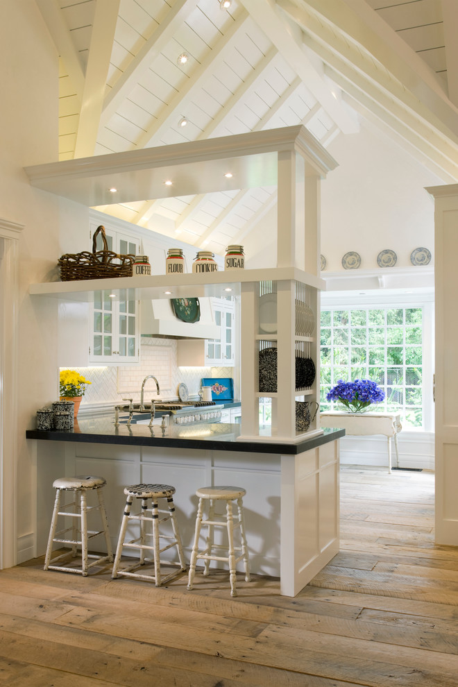 На фото: кухня в классическом стиле с стеклянными фасадами, белыми фасадами и белым фартуком с