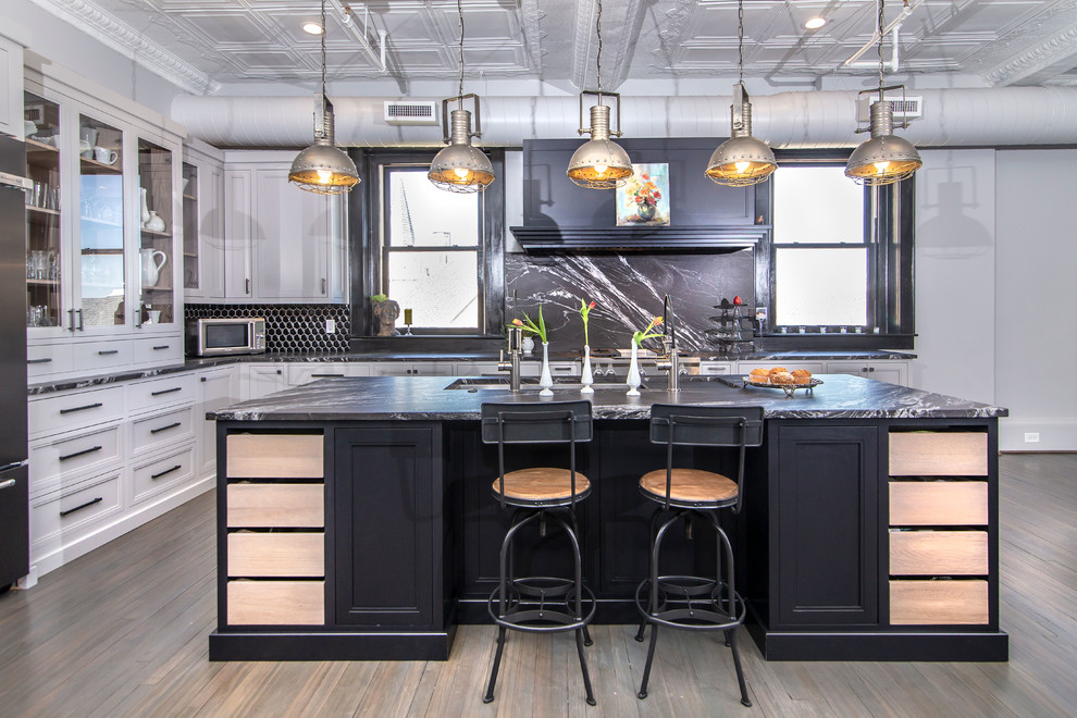 Large urban l-shaped dark wood floor and brown floor kitchen photo in Charlotte with black backsplash, stainless steel appliances, black countertops, an undermount sink, recessed-panel cabinets, white cabinets and an island