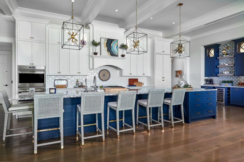 Design ideas for a large nautical galley kitchen/diner in Charleston with a submerged sink, white cabinets, white splashback, metro tiled splashback, stainless steel appliances, dark hardwood flooring, an island, brown floors and white worktops.