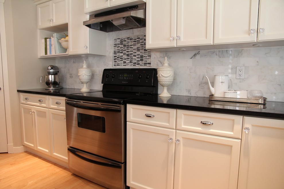 Large transitional l-shaped light wood floor eat-in kitchen photo in Vancouver with an undermount sink, shaker cabinets, white cabinets, marble countertops, gray backsplash and stainless steel appliances