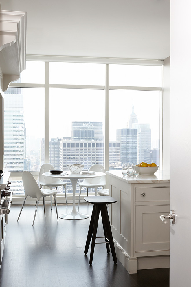 Foto på ett mellanstort funkis vit kök och matrum, med skåp i shakerstil, vita skåp, marmorbänkskiva, rostfria vitvaror, mörkt trägolv, en halv köksö och brunt golv