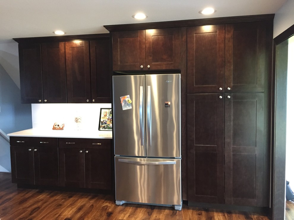 Inspiration for a medium sized contemporary u-shaped open plan kitchen in Other with a built-in sink, shaker cabinets, dark wood cabinets, glass worktops, stainless steel appliances, medium hardwood flooring and multiple islands.