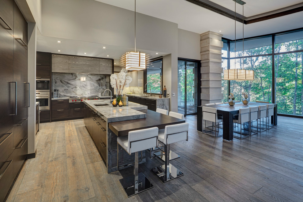 Esempio di una cucina minimal con lavello sottopiano, ante lisce, ante in legno bruno, paraspruzzi grigio, paraspruzzi in lastra di pietra, elettrodomestici in acciaio inossidabile, parquet scuro, pavimento marrone e top grigio