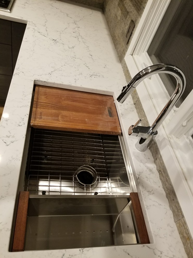 Large minimalist u-shaped dark wood floor and brown floor eat-in kitchen photo in Detroit with an undermount sink, glass-front cabinets, gray cabinets, quartz countertops, multicolored backsplash, stone tile backsplash, stainless steel appliances, a peninsula and white countertops