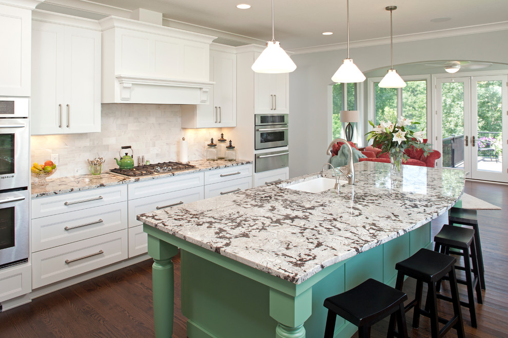 Eat-in kitchen - huge traditional galley dark wood floor eat-in kitchen idea in Minneapolis with an undermount sink, raised-panel cabinets, white cabinets, granite countertops, multicolored backsplash, subway tile backsplash, stainless steel appliances and an island