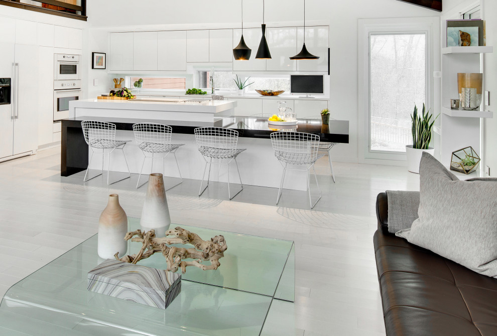 Modern inredning av ett mellanstort kök, med ljust trägolv, vitt golv, en undermonterad diskho, släta luckor, vita skåp, bänkskiva i kvarts, fönster som stänkskydd, vita vitvaror och en köksö