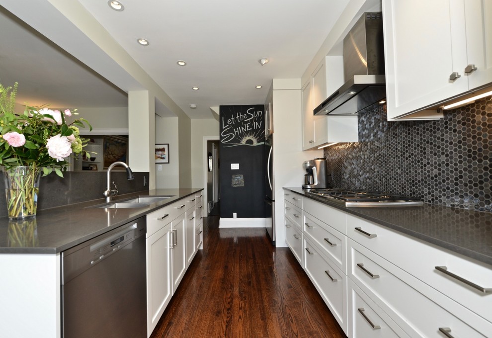 Inspiration for a mid-sized contemporary galley dark wood floor and brown floor eat-in kitchen remodel in Toronto with an undermount sink, shaker cabinets, white cabinets, solid surface countertops, gray backsplash, glass tile backsplash, stainless steel appliances, an island and gray countertops