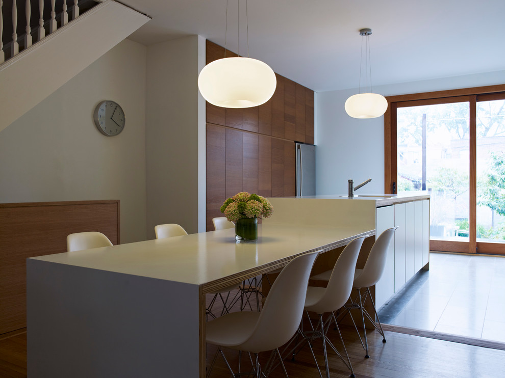 Modern kitchen/diner in Toronto with flat-panel cabinets, medium wood cabinets and stainless steel appliances.