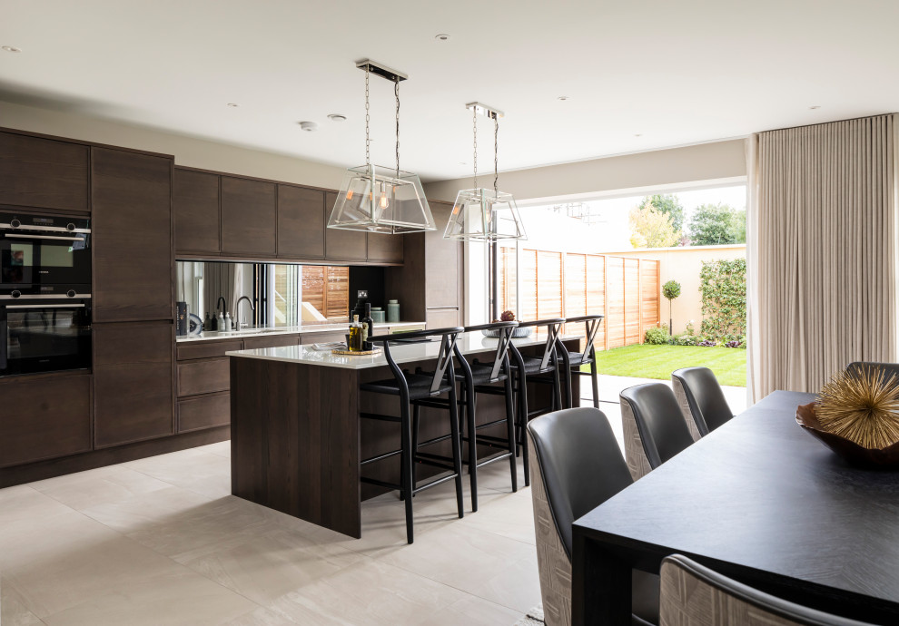 Design ideas for a large contemporary galley kitchen/diner in London with a submerged sink, flat-panel cabinets, medium wood cabinets, white splashback, mirror splashback, black appliances, porcelain flooring, an island, beige floors and brown worktops.