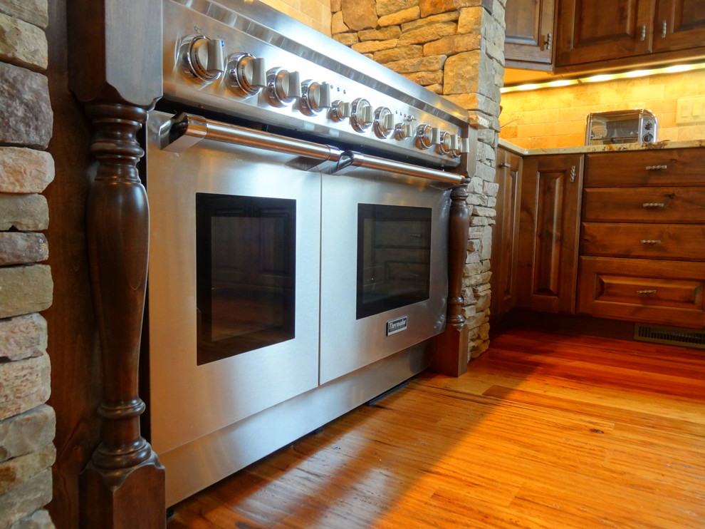 Exempel på ett stort rustikt kök, med en undermonterad diskho, luckor med upphöjd panel, skåp i mellenmörkt trä, marmorbänkskiva, beige stänkskydd, stänkskydd i keramik, rostfria vitvaror, mellanmörkt trägolv och en köksö