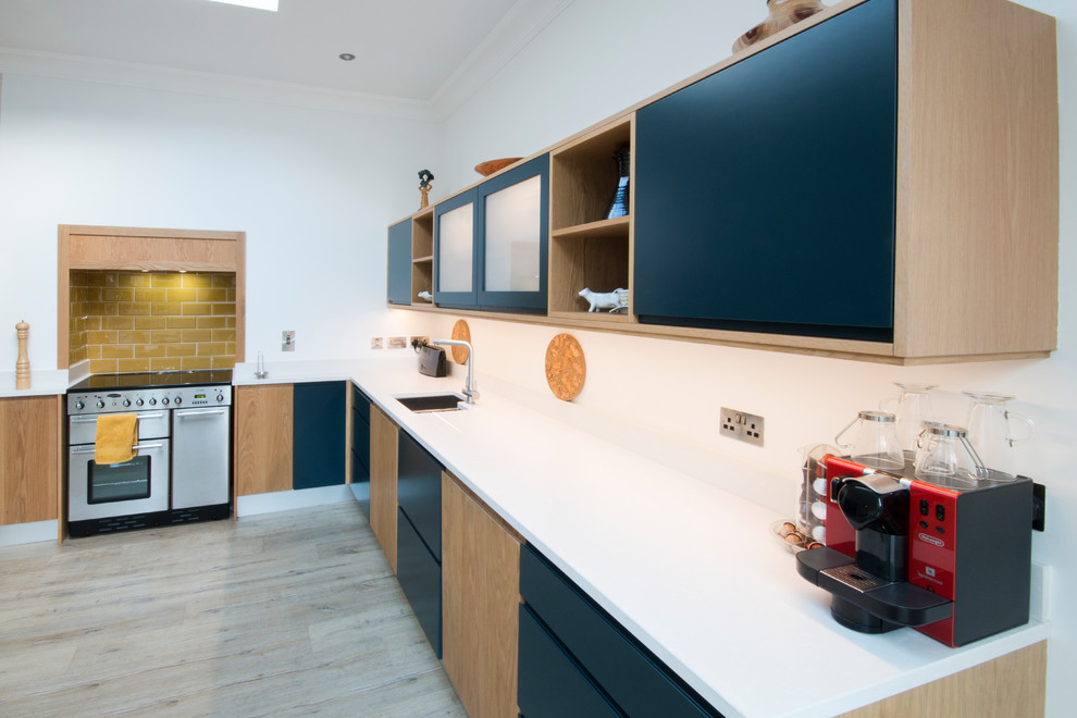 Idéer för ett mellanstort modernt kök, med släta luckor, blå skåp, bänkskiva i kvartsit, laminatgolv, gult stänkskydd, stänkskydd i porslinskakel och grått golv