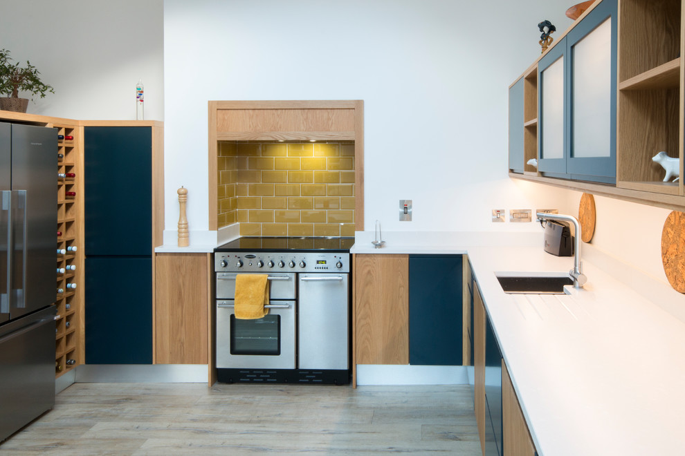 Immagine di una cucina contemporanea di medie dimensioni con ante lisce, ante blu, top in quarzite, paraspruzzi bianco e pavimento in laminato