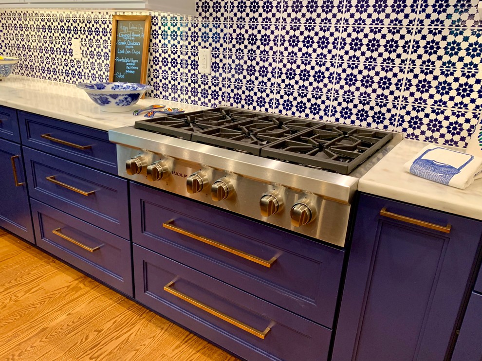 Inspiration for a mid-sized timeless u-shaped medium tone wood floor open concept kitchen remodel in Milwaukee with a farmhouse sink, recessed-panel cabinets, blue cabinets, marble countertops, multicolored backsplash, terra-cotta backsplash, paneled appliances, an island and white countertops