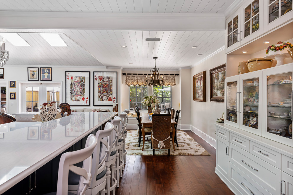 Imagen de cocina campestre grande abierta con fregadero sobremueble, armarios estilo shaker, puertas de armario blancas, salpicadero verde, electrodomésticos de colores, suelo de madera oscura, una isla, suelo marrón y encimeras blancas