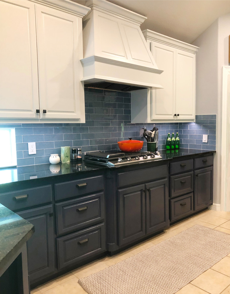 Esempio di un cucina con isola centrale boho chic di medie dimensioni con ante con bugna sagomata, ante blu, top in granito, paraspruzzi blu, paraspruzzi con piastrelle di vetro, elettrodomestici in acciaio inossidabile e top nero