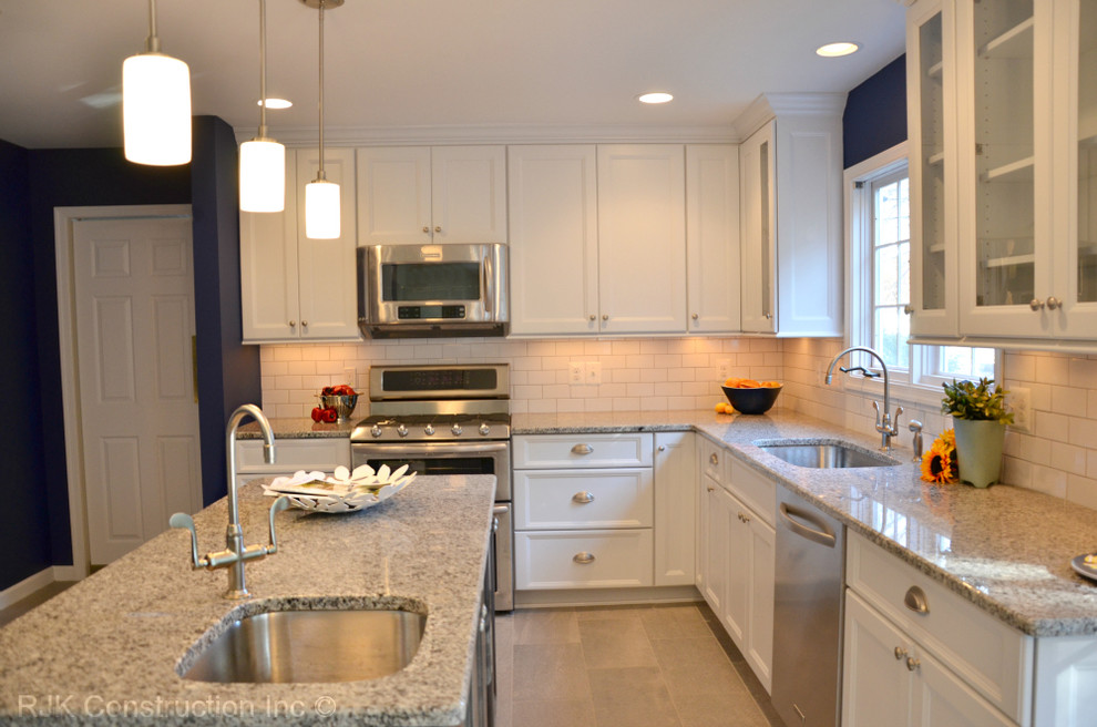 Example of a classic l-shaped ceramic tile eat-in kitchen design in DC Metro with an undermount sink, shaker cabinets, white cabinets, granite countertops, white backsplash, subway tile backsplash, stainless steel appliances and an island
