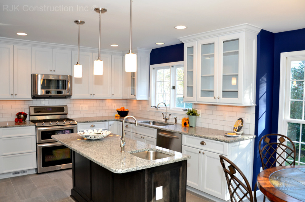 Elegant l-shaped ceramic tile eat-in kitchen photo in DC Metro with an undermount sink, shaker cabinets, white cabinets, granite countertops, white backsplash, subway tile backsplash, stainless steel appliances and an island