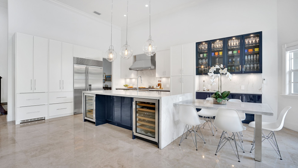 Inspiration for a large contemporary l-shaped porcelain tile, beige floor and vaulted ceiling open concept kitchen remodel in Miami with an undermount sink, recessed-panel cabinets, blue cabinets, quartzite countertops, beige backsplash, white appliances, an island and beige countertops