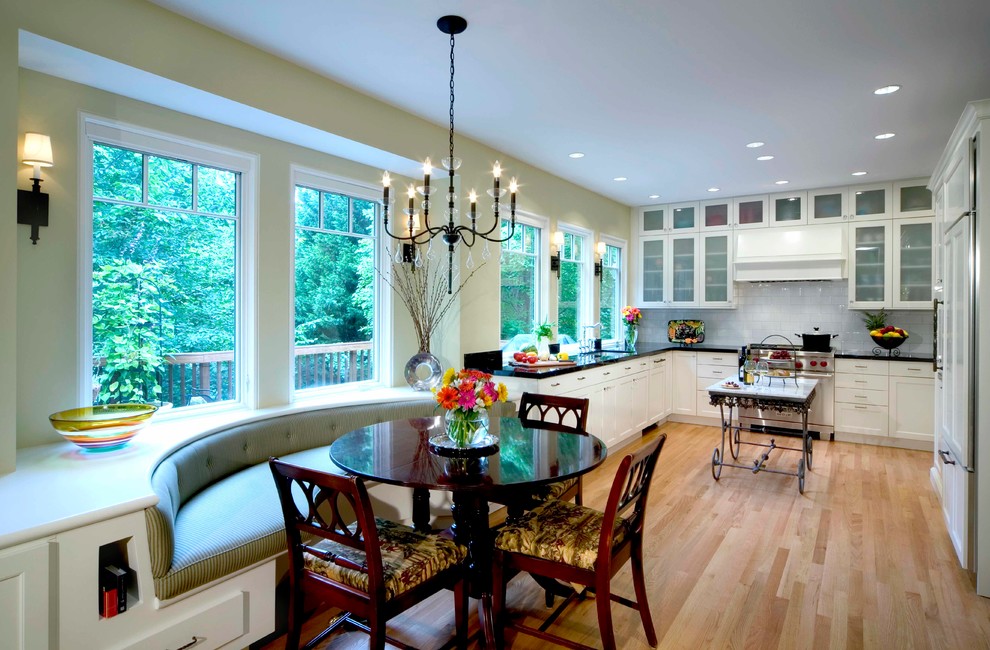 Example of a classic l-shaped eat-in kitchen design in DC Metro with shaker cabinets, white cabinets, white backsplash, subway tile backsplash and paneled appliances