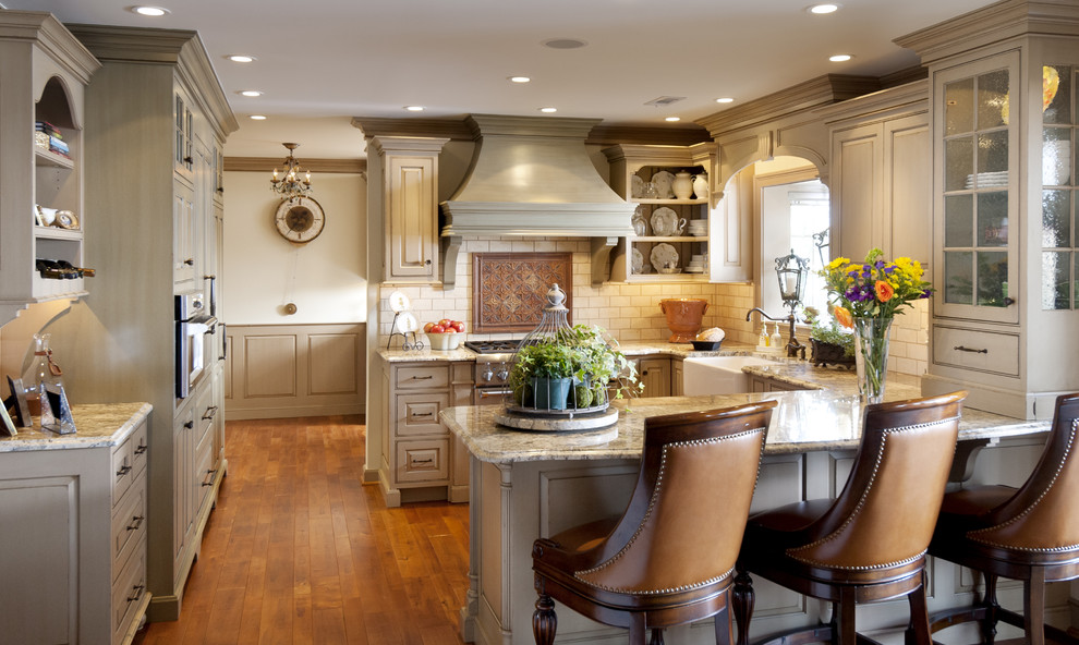 Exempel på ett mellanstort klassiskt kök, med luckor med upphöjd panel, en rustik diskho, grå skåp, granitbänkskiva, vitt stänkskydd, stänkskydd i tunnelbanekakel, rostfria vitvaror, mellanmörkt trägolv och en halv köksö