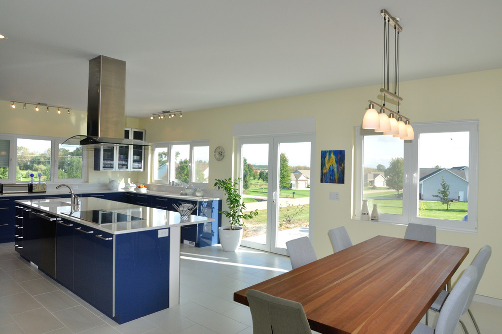 Modelo de cocina comedor minimalista grande con armarios con paneles lisos, puertas de armario azules y una isla