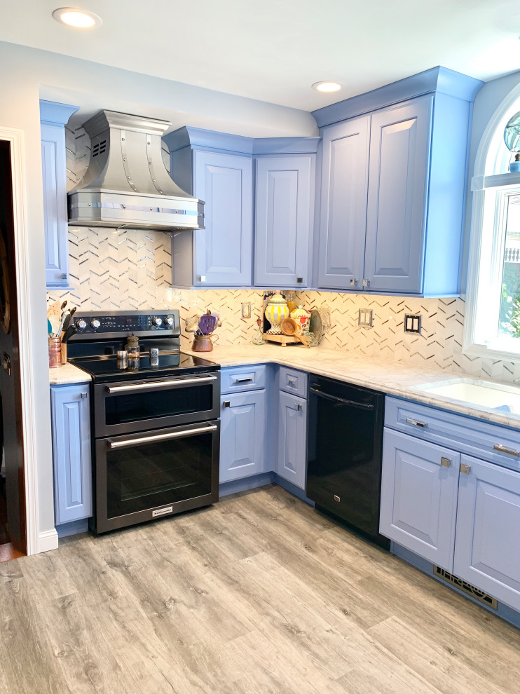 Eat-in kitchen - mid-sized country galley vinyl floor and brown floor eat-in kitchen idea in Other with a farmhouse sink, recessed-panel cabinets, blue cabinets, quartz countertops, multicolored backsplash, mosaic tile backsplash, black appliances, an island and gray countertops