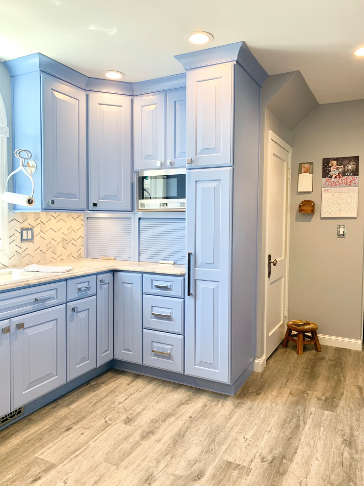 Mid-sized cottage galley vinyl floor and brown floor eat-in kitchen photo in Other with a farmhouse sink, recessed-panel cabinets, blue cabinets, quartz countertops, multicolored backsplash, mosaic tile backsplash, black appliances, an island and gray countertops