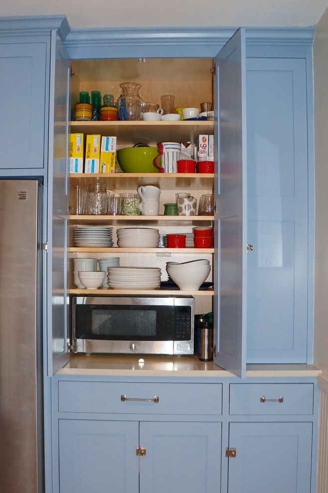 Foto på ett litet vintage kök, med en enkel diskho, skåp i shakerstil, blå skåp, bänkskiva i kvarts, vitt stänkskydd, rostfria vitvaror, ljust trägolv och en köksö
