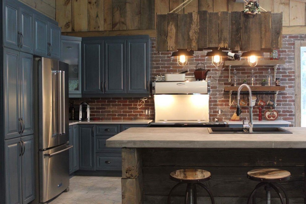 Exempel på ett litet lantligt kök, med en nedsänkt diskho, luckor med upphöjd panel, blå skåp, bänkskiva i betong, rött stänkskydd, stänkskydd i tegel, rostfria vitvaror, klinkergolv i keramik, en köksö och grått golv