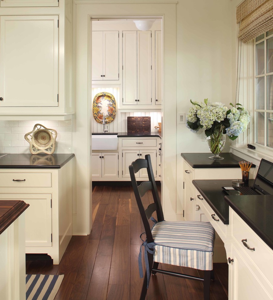 Design ideas for a large classic kitchen/diner in Charleston with a belfast sink, beaded cabinets, white cabinets, white splashback, cement tile splashback, dark hardwood flooring and an island.