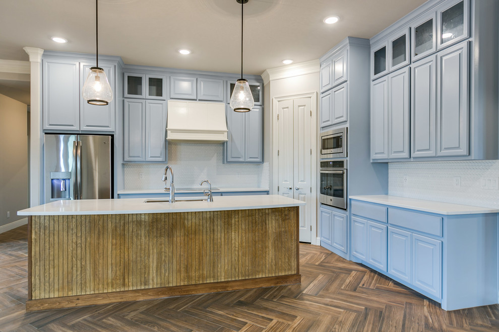 Exempel på ett mellanstort eklektiskt vit vitt kök, med en rustik diskho, luckor med upphöjd panel, blå skåp, bänkskiva i kvarts, vitt stänkskydd, stänkskydd i mosaik, rostfria vitvaror, klinkergolv i keramik, en köksö och brunt golv