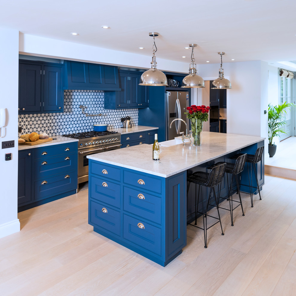 Inspiration för stora moderna beige kök, med en rustik diskho, luckor med infälld panel, blå skåp, marmorbänkskiva, blått stänkskydd, rostfria vitvaror, ljust trägolv, en köksö och beiget golv