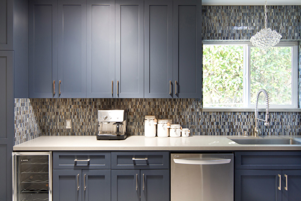 Ejemplo de cocina contemporánea con armarios estilo shaker, puertas de armario azules, encimera de cuarzo compacto, salpicadero azul y electrodomésticos de acero inoxidable