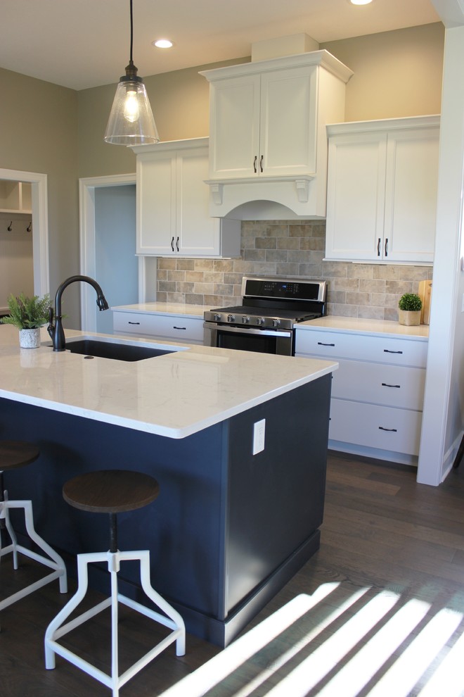 Foto på ett stort nordiskt vit kök, med en undermonterad diskho, släta luckor, blå skåp, bänkskiva i kvarts, beige stänkskydd, stänkskydd i porslinskakel, rostfria vitvaror, mellanmörkt trägolv, en köksö och grått golv
