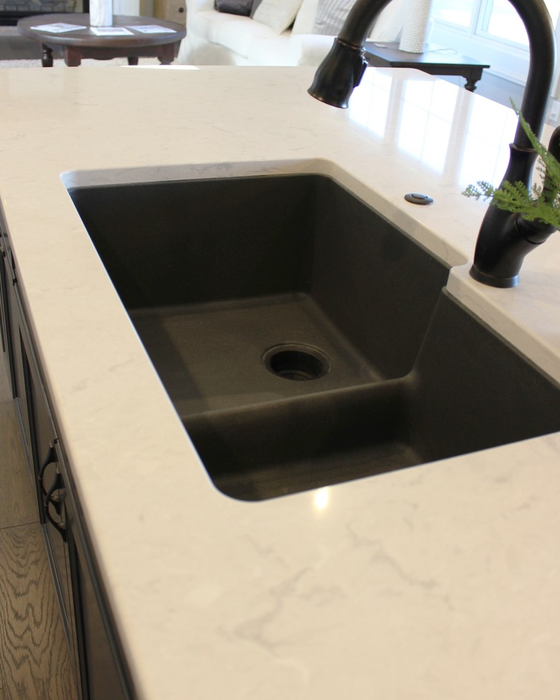 Modelo de cocinas en L escandinava, grande, abierta, con fregadero bajoencimera, armarios con paneles lisos, puertas de armario azules, encimera de cuarzo compacto, salpicadero beige, salpicadero de azulejos de porcelana, electrodomésticos de acero inoxidable, suelo de madera en tonos medios, una isla, suelo gris y encimeras blancas