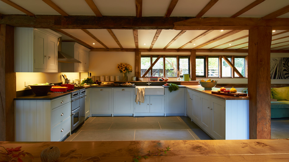 Foto på ett mellanstort lantligt kök, med en halv köksö, skåp i shakerstil, blå skåp, granitbänkskiva, beige stänkskydd, färgglada vitvaror och en rustik diskho