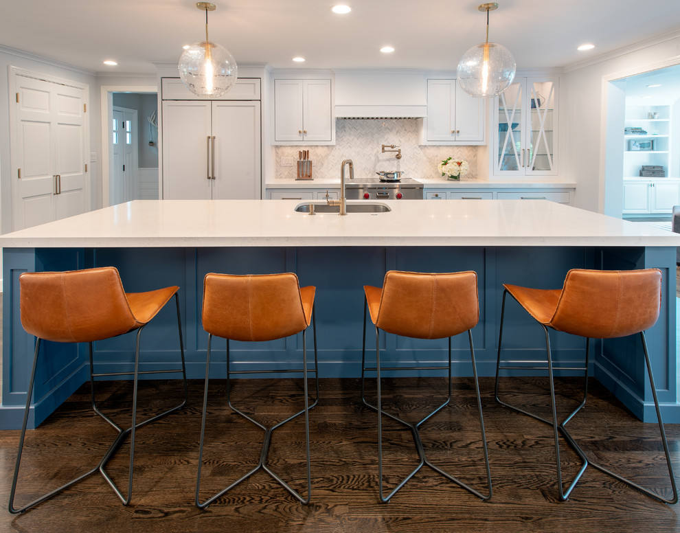 Inspiration for a coastal medium tone wood floor and brown floor kitchen remodel in Boston with white cabinets, white backsplash, marble backsplash, paneled appliances, an island and white countertops