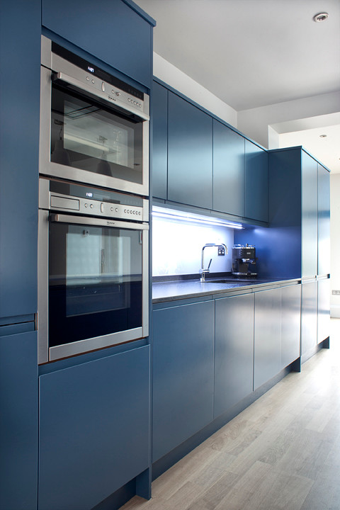 Zweizeilige, Mittelgroße Moderne Wohnküche mit Waschbecken, flächenbündigen Schrankfronten, blauen Schränken, Küchengeräten aus Edelstahl und Kücheninsel in Essex