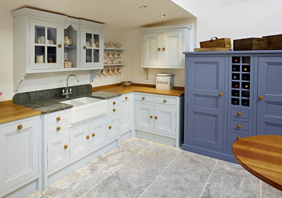 Medium sized classic l-shaped kitchen in Other with a belfast sink, beaded cabinets, blue cabinets and travertine flooring.