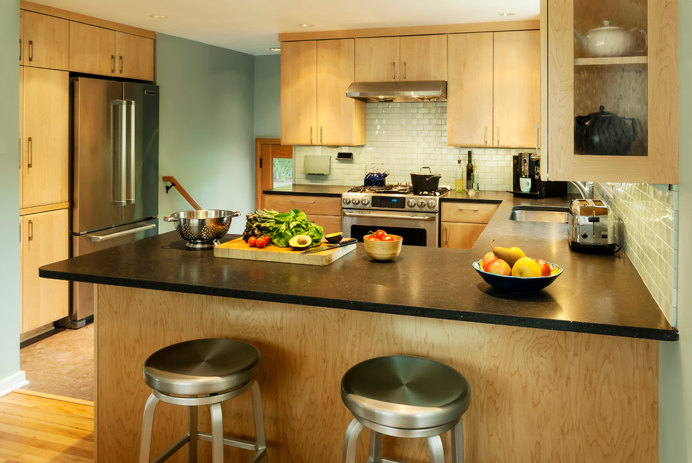 Exempel på ett mellanstort 50 tals kök, med en undermonterad diskho, skåp i ljust trä, blått stänkskydd, stänkskydd i tunnelbanekakel, rostfria vitvaror, korkgolv och en halv köksö