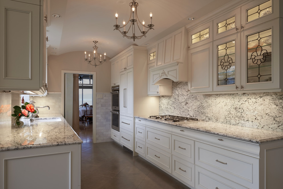 Example of a small classic galley porcelain tile open concept kitchen design in Seattle with beaded inset cabinets, white cabinets, granite countertops, stone slab backsplash, paneled appliances, no island, an undermount sink and white backsplash