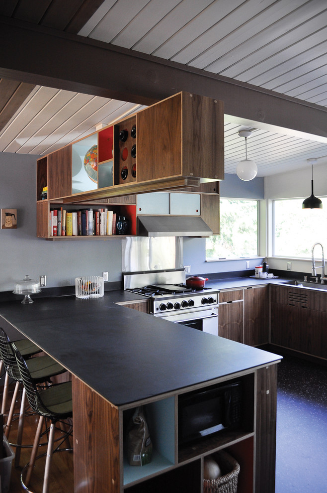 Modern u-shaped kitchen in Seattle with flat-panel cabinets, dark wood cabinets and stainless steel appliances.
