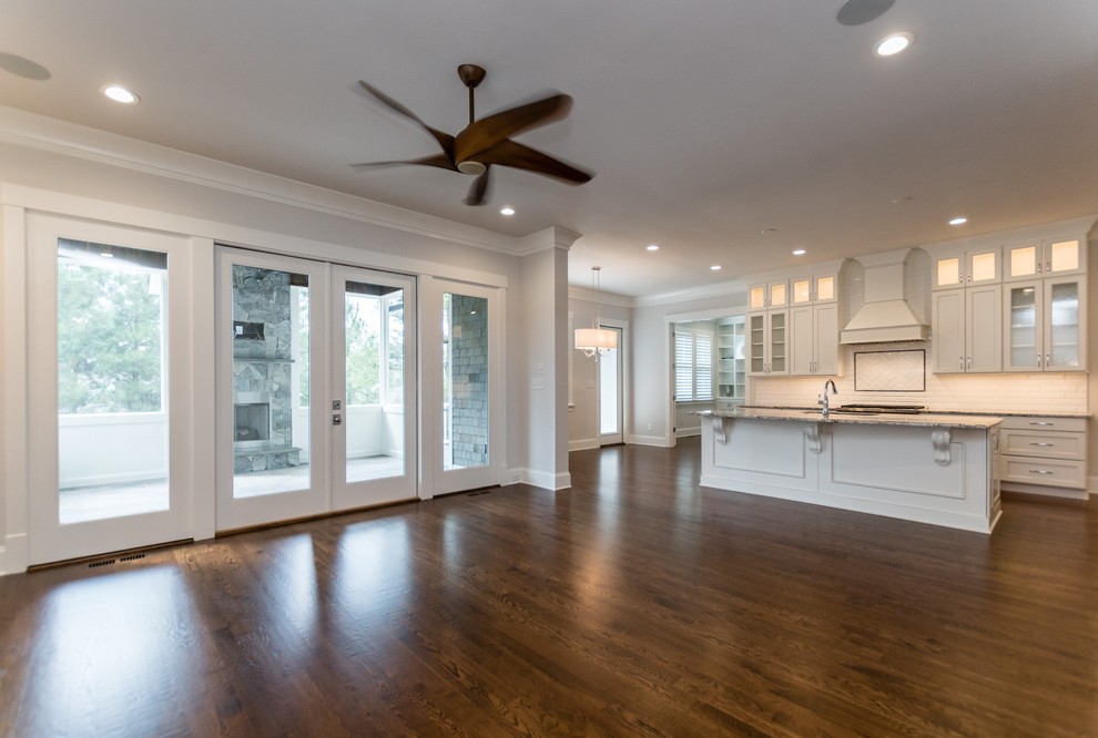 Example of a large transitional u-shaped dark wood floor and brown floor open concept kitchen design in Raleigh with an undermount sink, recessed-panel cabinets, white cabinets, granite countertops, white backsplash, subway tile backsplash, stainless steel appliances and an island