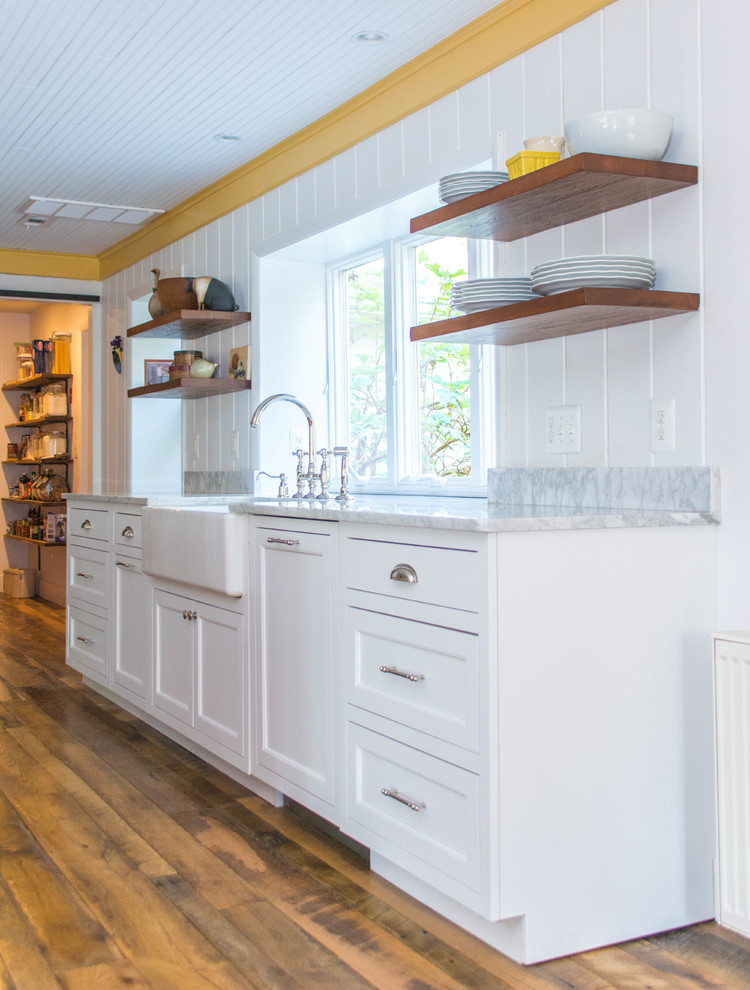 Photo of a medium sized farmhouse galley kitchen/diner in DC Metro with a belfast sink, flat-panel cabinets, white cabinets, wood worktops, multi-coloured splashback, integrated appliances, medium hardwood flooring, an island, brown floors and brown worktops.