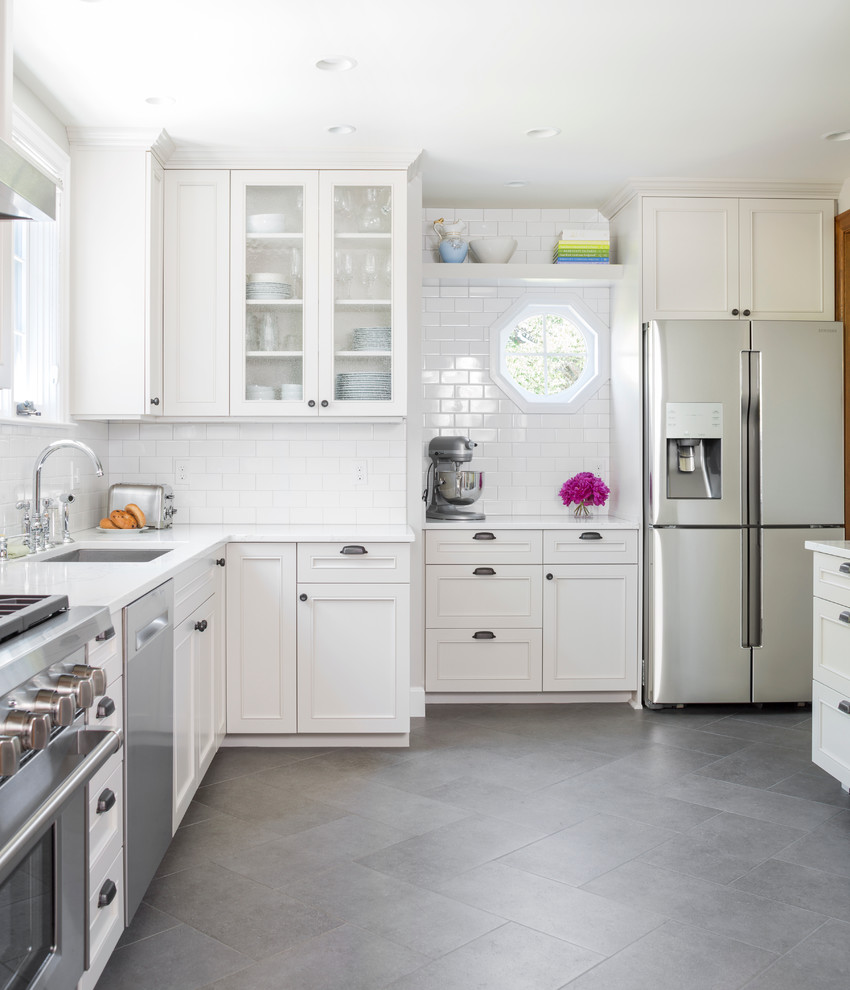 Medium sized classic l-shaped kitchen in Seattle with a submerged sink, white cabinets, engineered stone countertops, white splashback, metro tiled splashback, stainless steel appliances, porcelain flooring and beaded cabinets.