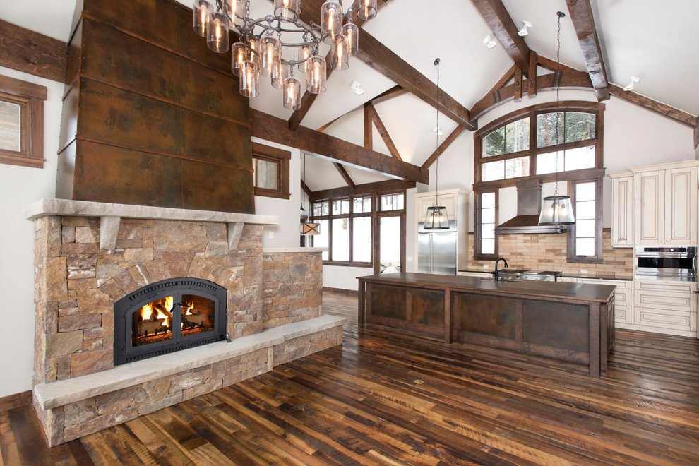 Photo of a rustic l-shaped open plan kitchen in Denver with a submerged sink, beaded cabinets, white cabinets, beige splashback, stainless steel appliances, medium hardwood flooring, an island and brown floors.