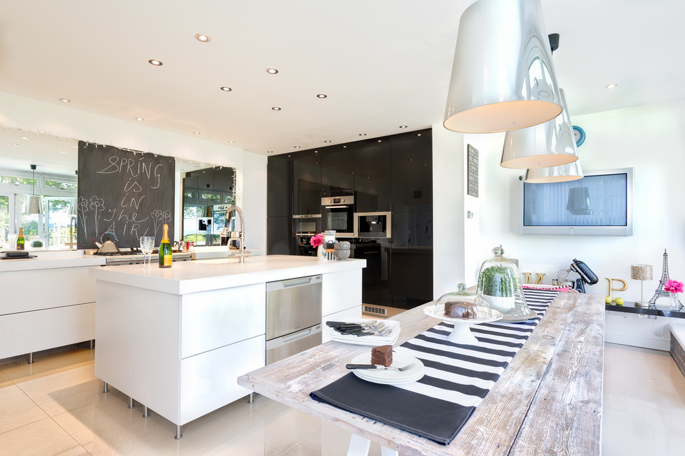 This is an example of a contemporary kitchen in Devon with flat-panel cabinets, black cabinets and stainless steel appliances.